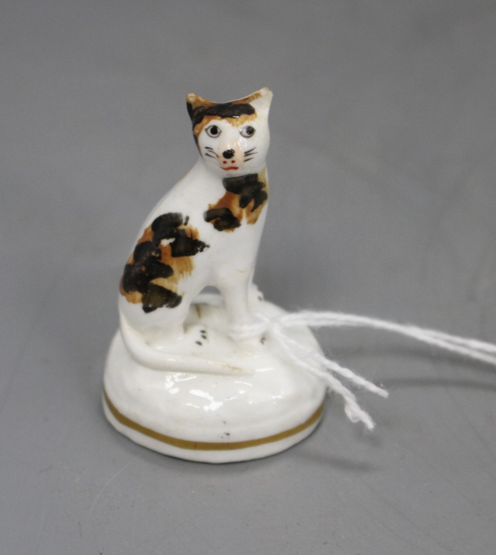 A rare Staffordshire porcelain toy figure of a seated tortoiseshell cat, c.1835-50, H. 4.4cm